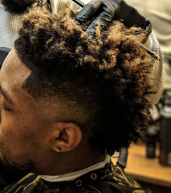 Side view of a client's curly hair with a clean fade at the temple
