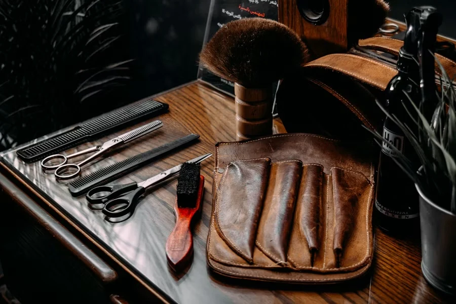 Barber's tools on a wooden counter: scissors, black combs, a brush, a leather tool roll and a shaving brush