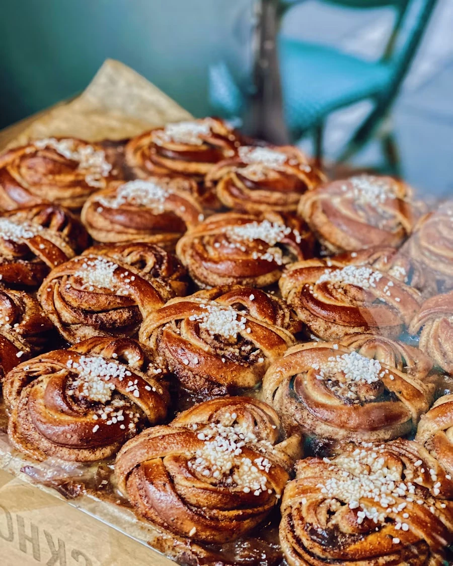 A tray of freshly baked cardamom buns twisted into knots and topped with pearl sugar