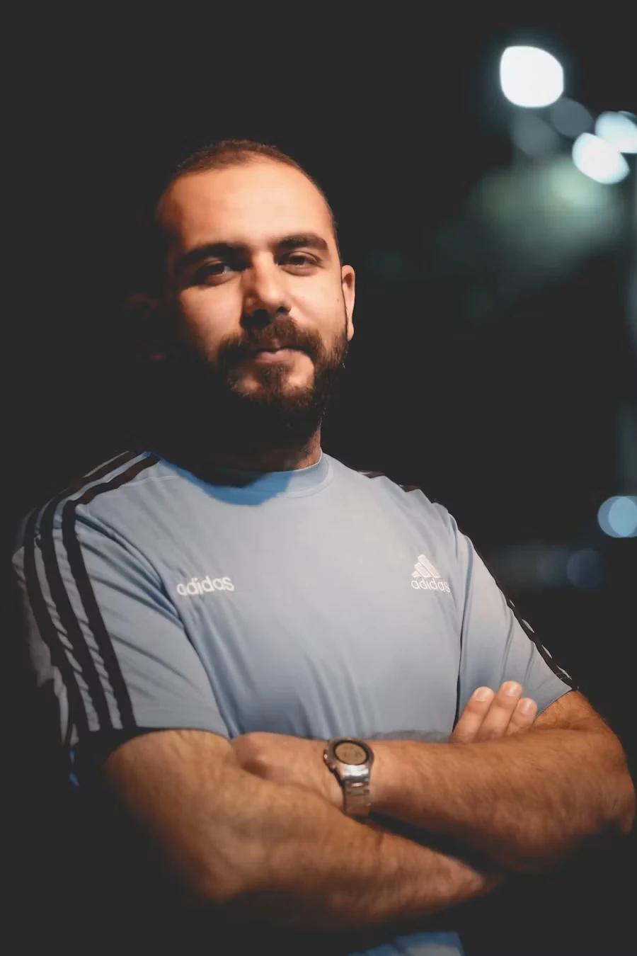 Bearded coach in a grey training shirt with arms crossed