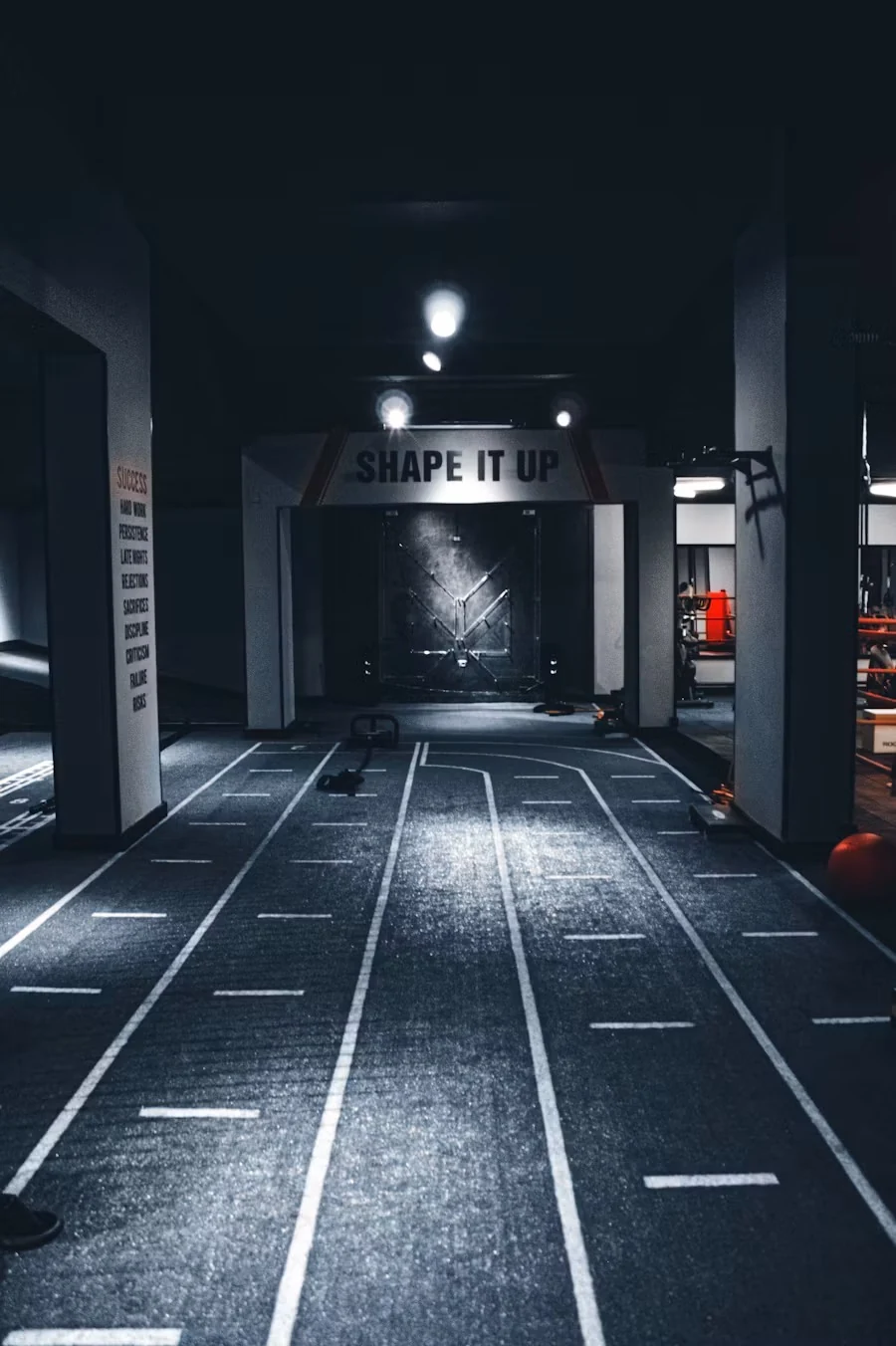 Dark sled track with white lane lines running toward a doorway