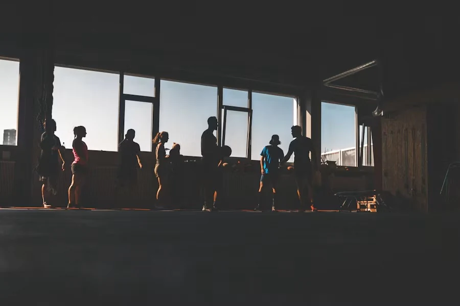Members silhouetted against large windows in the group-class studio
