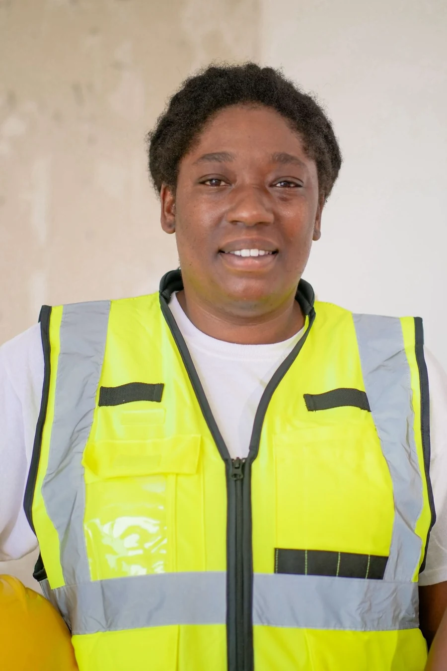 A smiling plumber in a hi-vis vest
